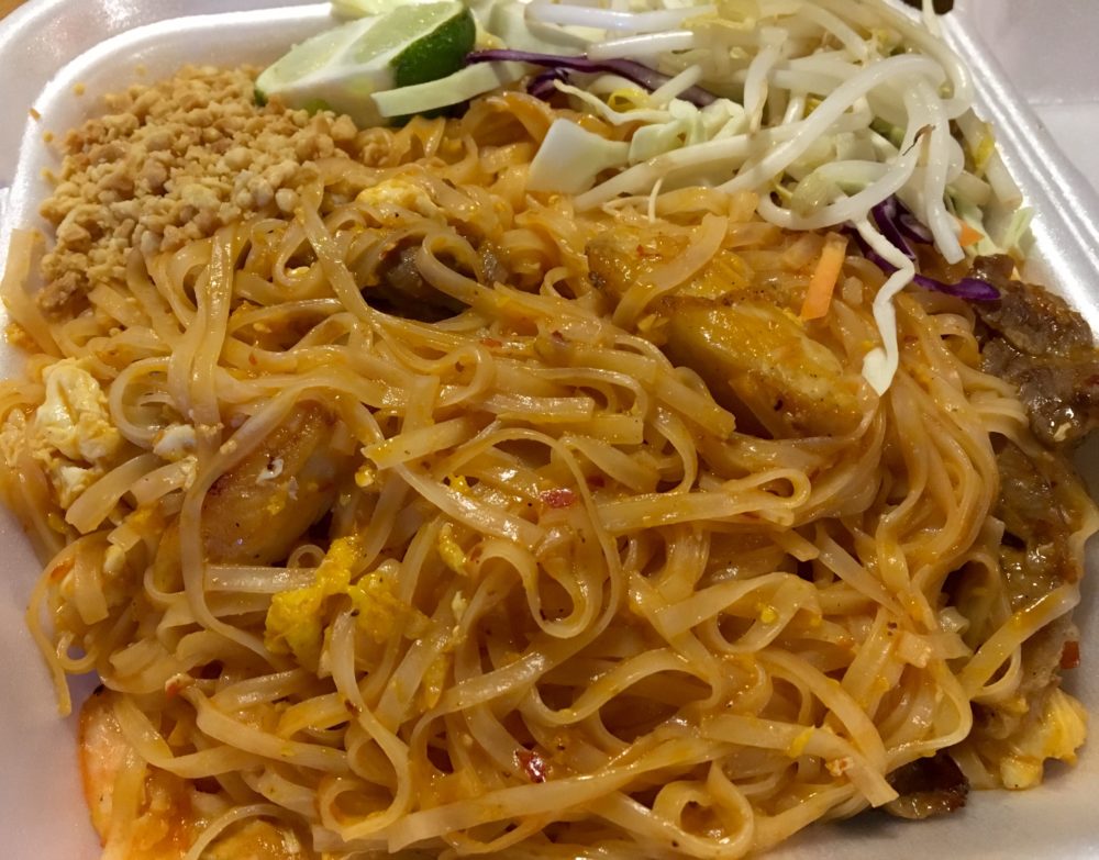 brown pad thai noodles with chicken, shrimp, and beef, topped with peanuts, bean sprouts, cabbage, and a lime wedge