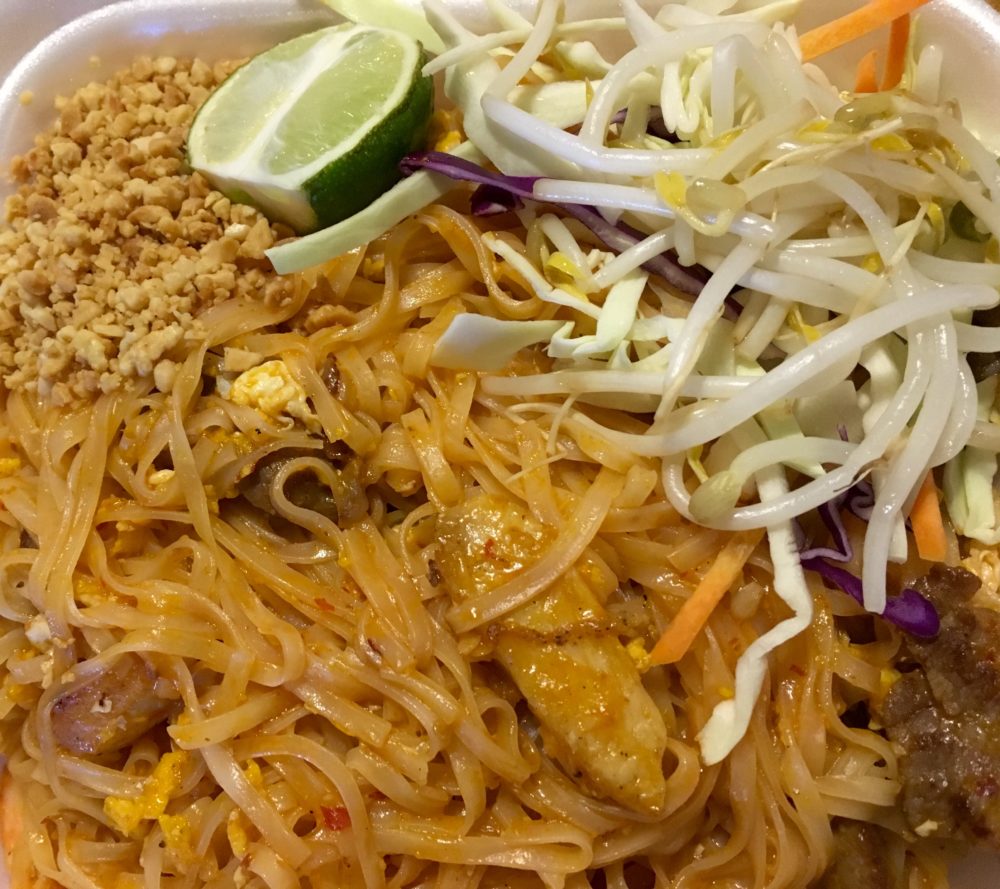 brown pad thai noodles with chicken, shrimp, and beef, topped with peanuts, bean sprouts, cabbage, and a lime wedge