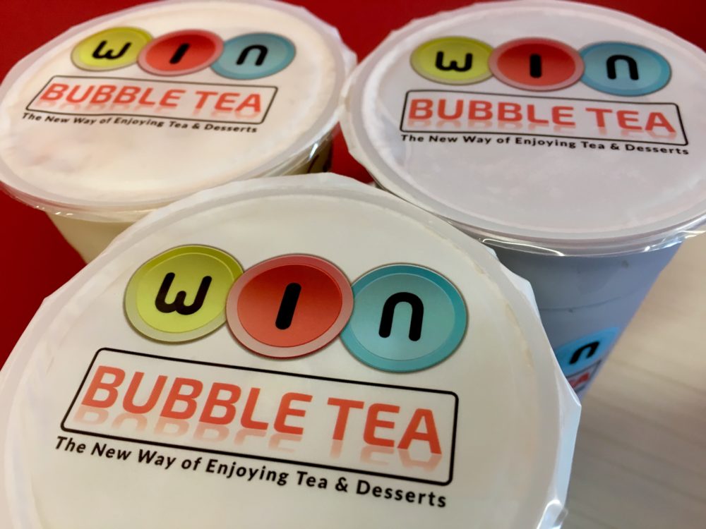 The lids of three bubble tea cups with the logo for WIN Bubble Tea in Nashville, Tennessee