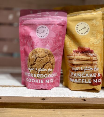 A pink bag of vegan snickerdoodle cookie mix, and a yellow bag of vegan pancake and waffle mix, both by Coconut Whisk of Minneapolis, Minnesota
