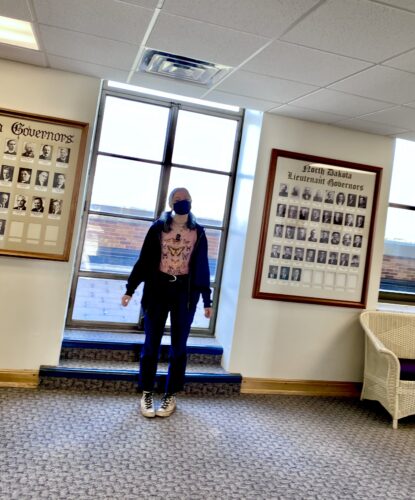 Trillian Celeste in the Top of the North Dakota State Capitol Building Standing in Front of Portraits of Past Governors and Lieutenant Governors