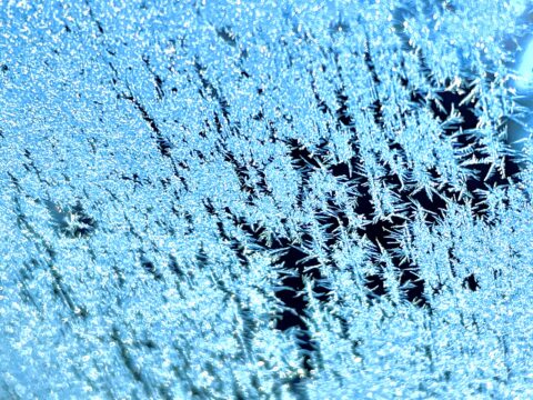 Blue ice crystals on the windshield of a car