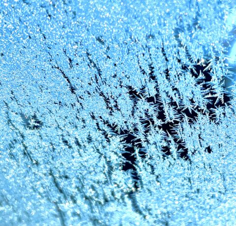 Blue ice crystals on the windshield of a car